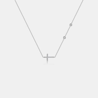 a diamond cross necklace on a white background