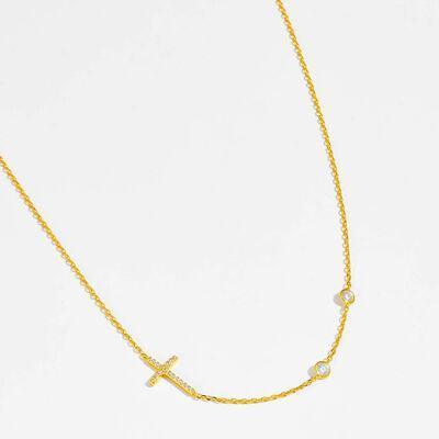 a gold necklace with a cross on it