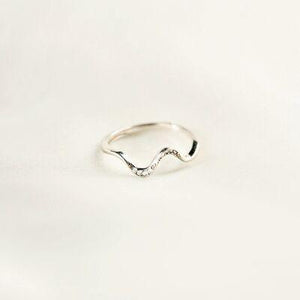 a silver ring with a wave design on it