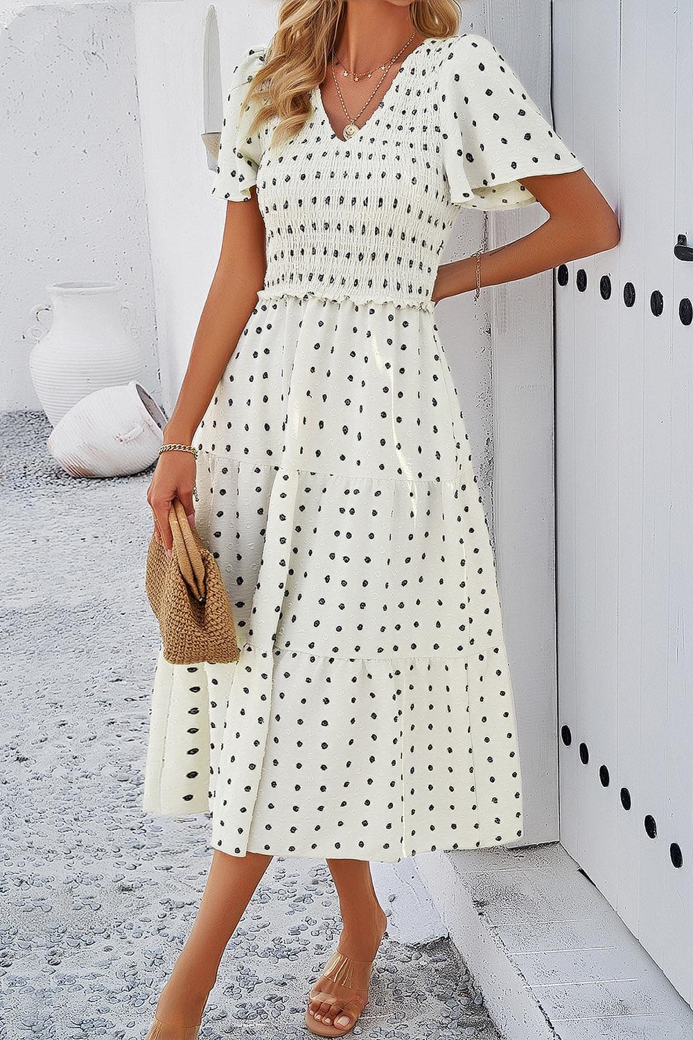 a woman wearing a white polka dot dress