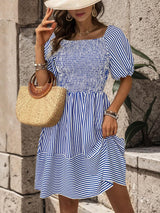 a woman wearing a blue and white striped dress