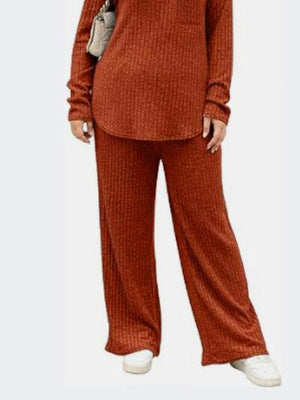 a woman wearing a red sweater and pants