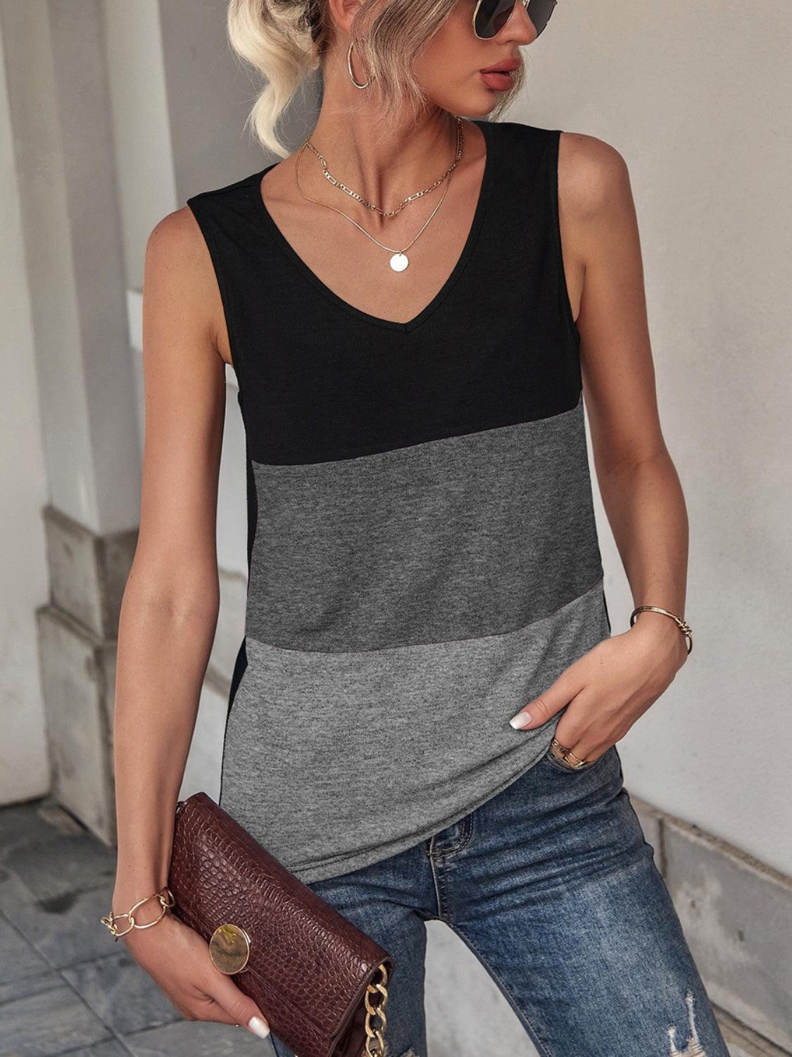 a woman wearing a black and grey top and jeans