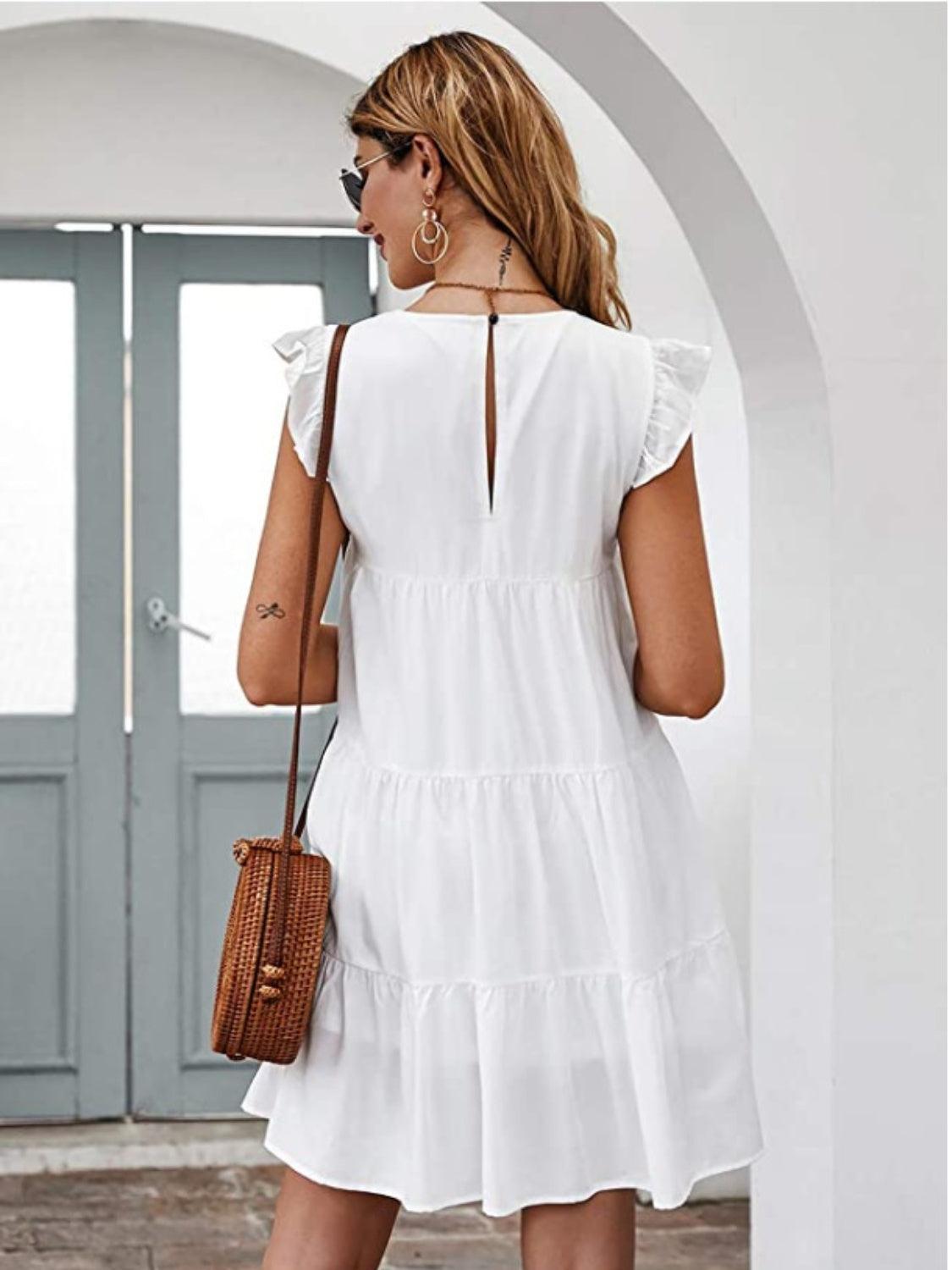 a woman in a white dress is holding a brown purse
