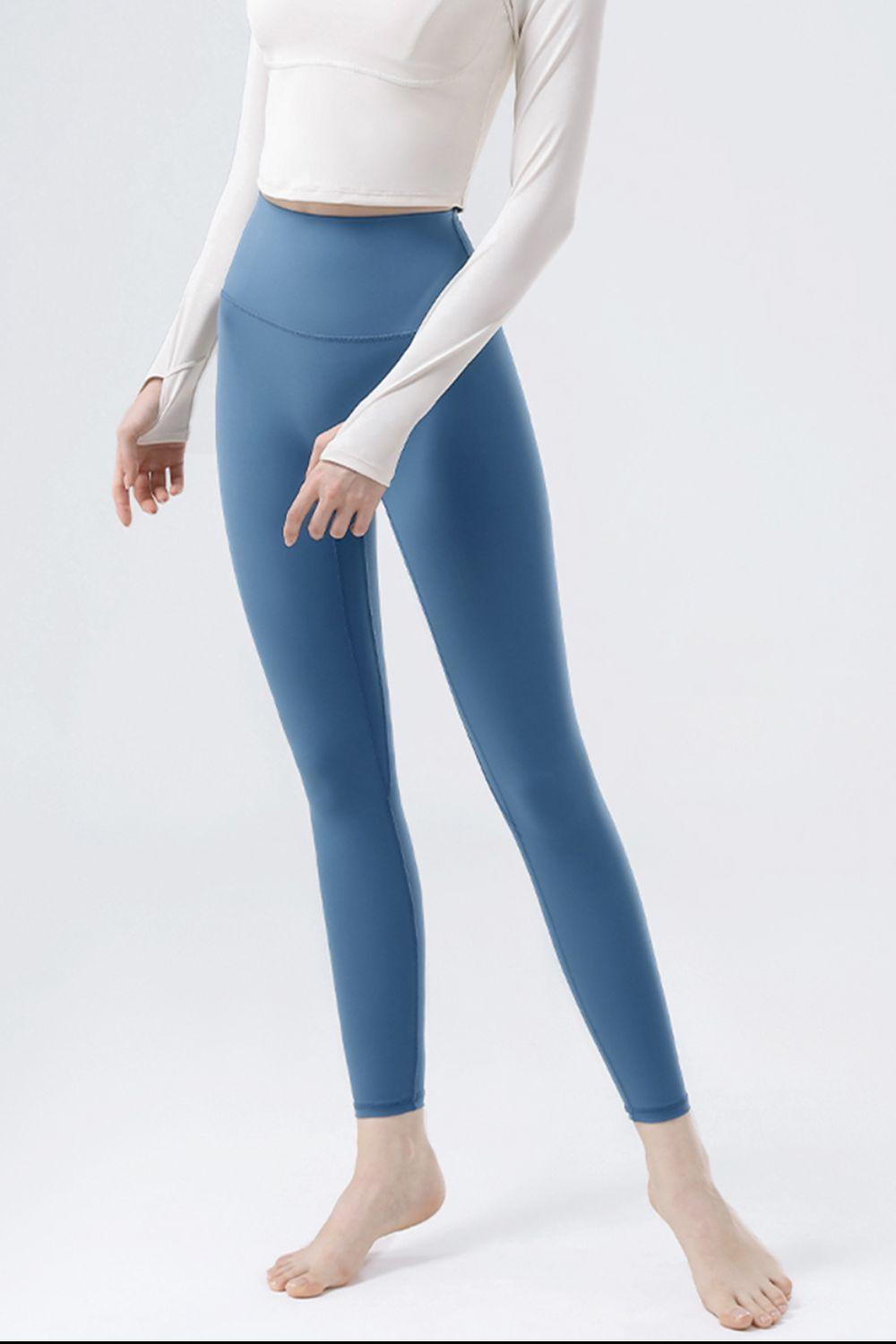 a woman in a white top and blue leggings