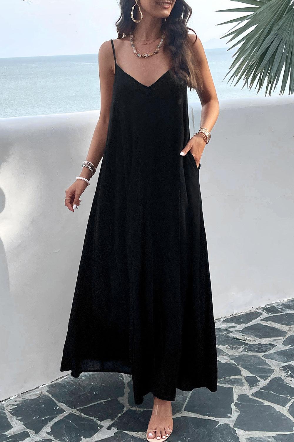 a woman in a black dress standing by the ocean