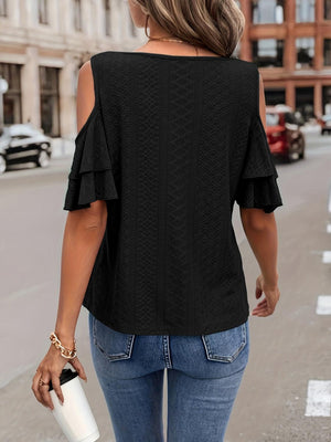 a woman walking down the street wearing a black top