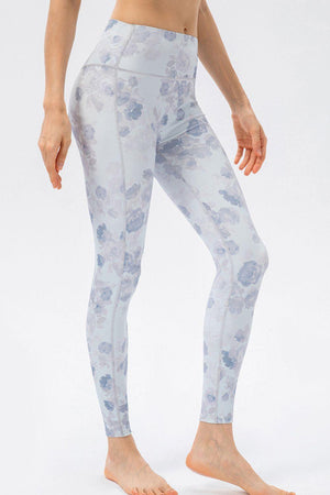 a woman in a white top and blue floral print leggings