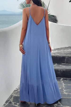 a woman in a blue dress looking at the ocean