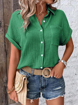 a woman wearing a green shirt and denim shorts