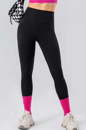 a woman in a pink top and black leggings