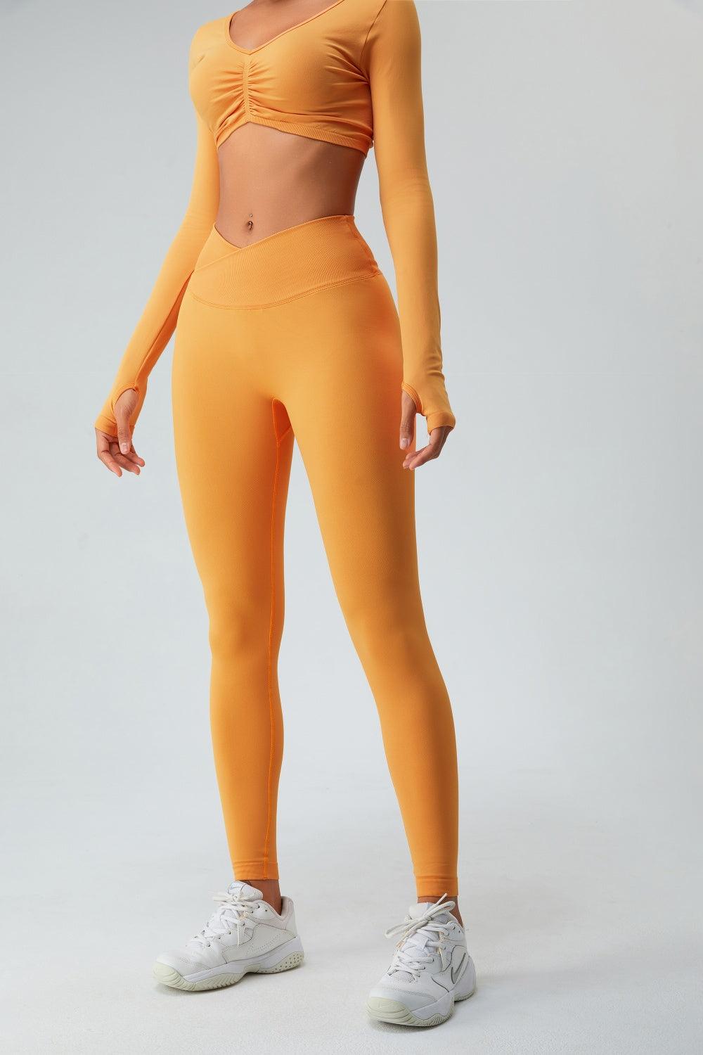 a woman in an orange sports bra top and leggings