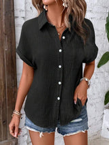 a woman wearing a black shirt and denim shorts