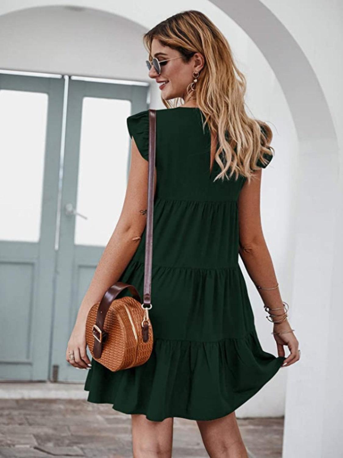 a woman in a green dress is holding a brown purse