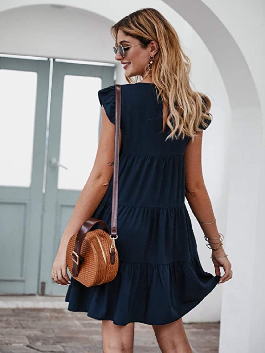 a woman in a blue dress carrying a brown purse