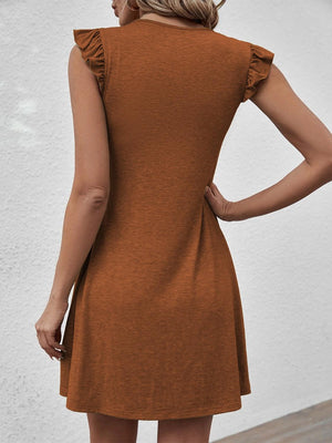 a woman wearing a brown dress with ruffles on the back