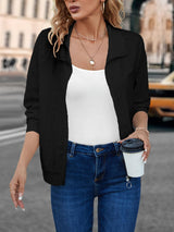 a woman holding a coffee cup and wearing a black jacket