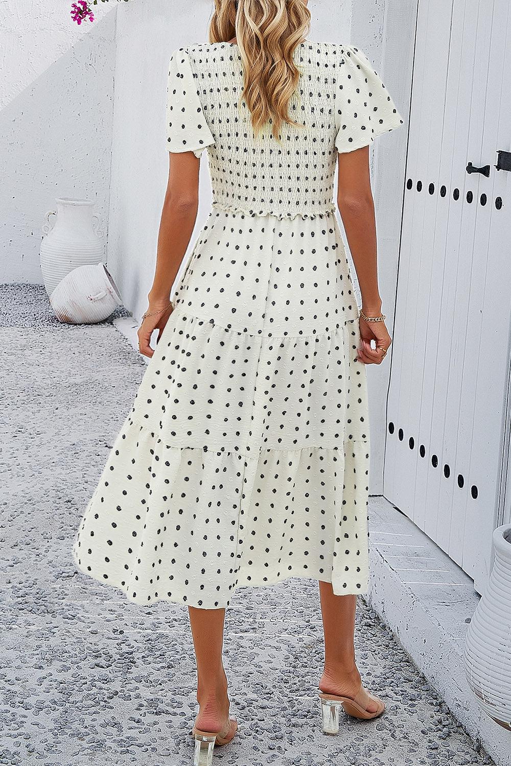 a woman in a white polka dot dress