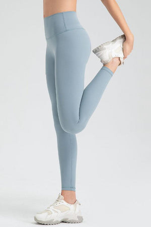 a woman in blue leggings holding a silver object