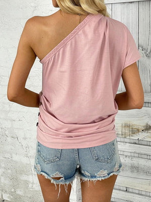 a woman wearing a pink top and denim shorts