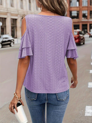 a woman walking down the street wearing a purple top