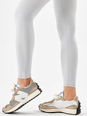 a woman's legs in white pants and sneakers