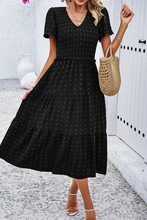 a woman wearing a black polka dot dress