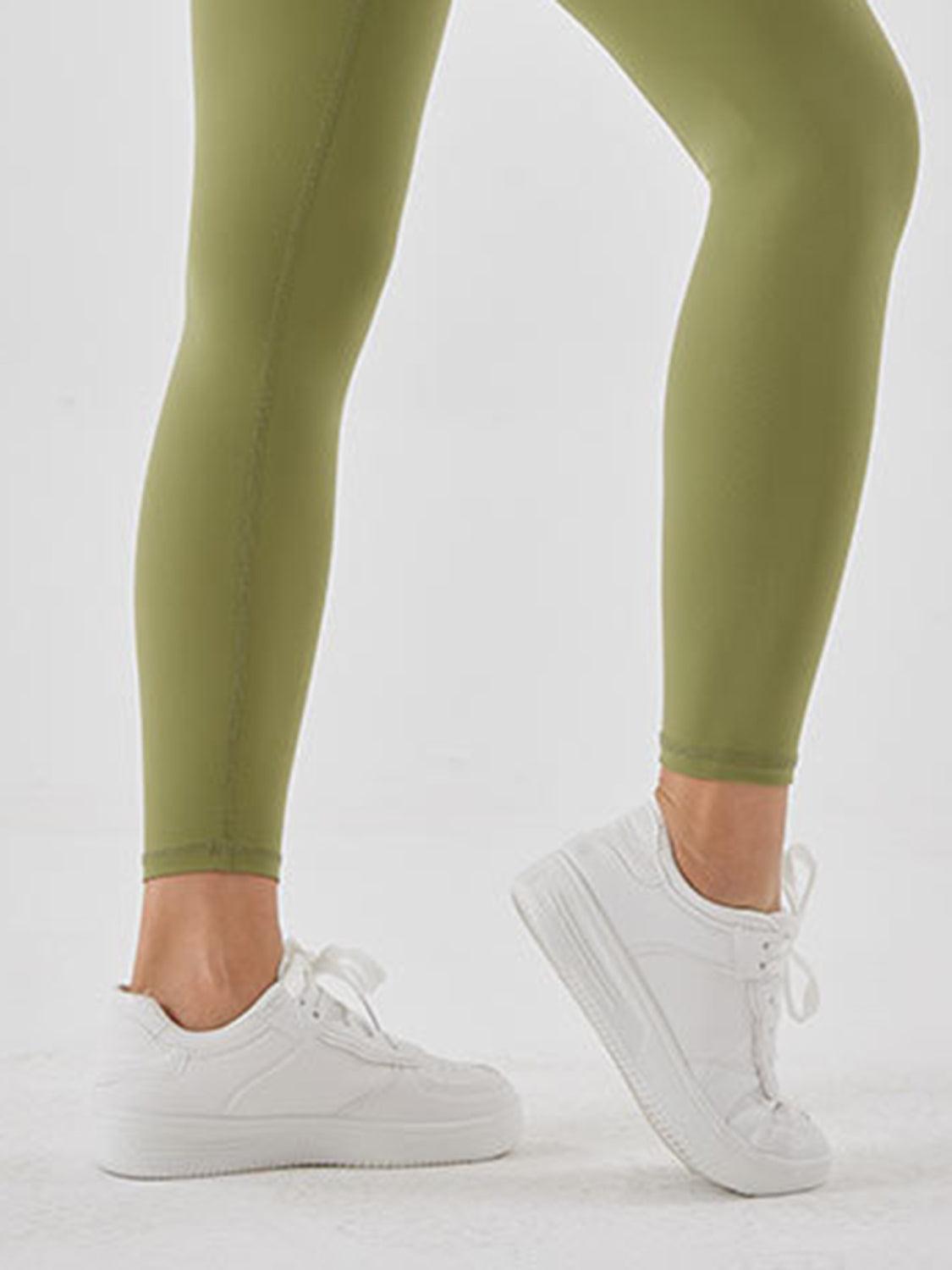 a woman in a white top and green leggings