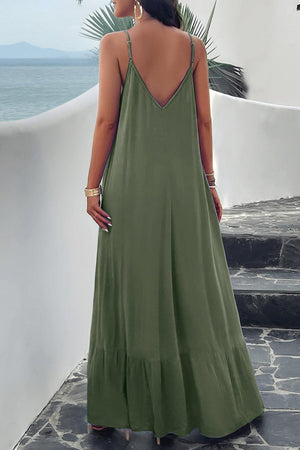 a woman in a green dress looking at the ocean