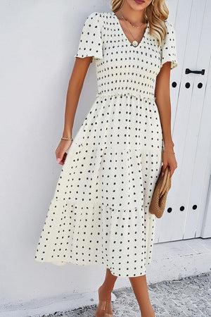 a woman wearing a white polka dot dress