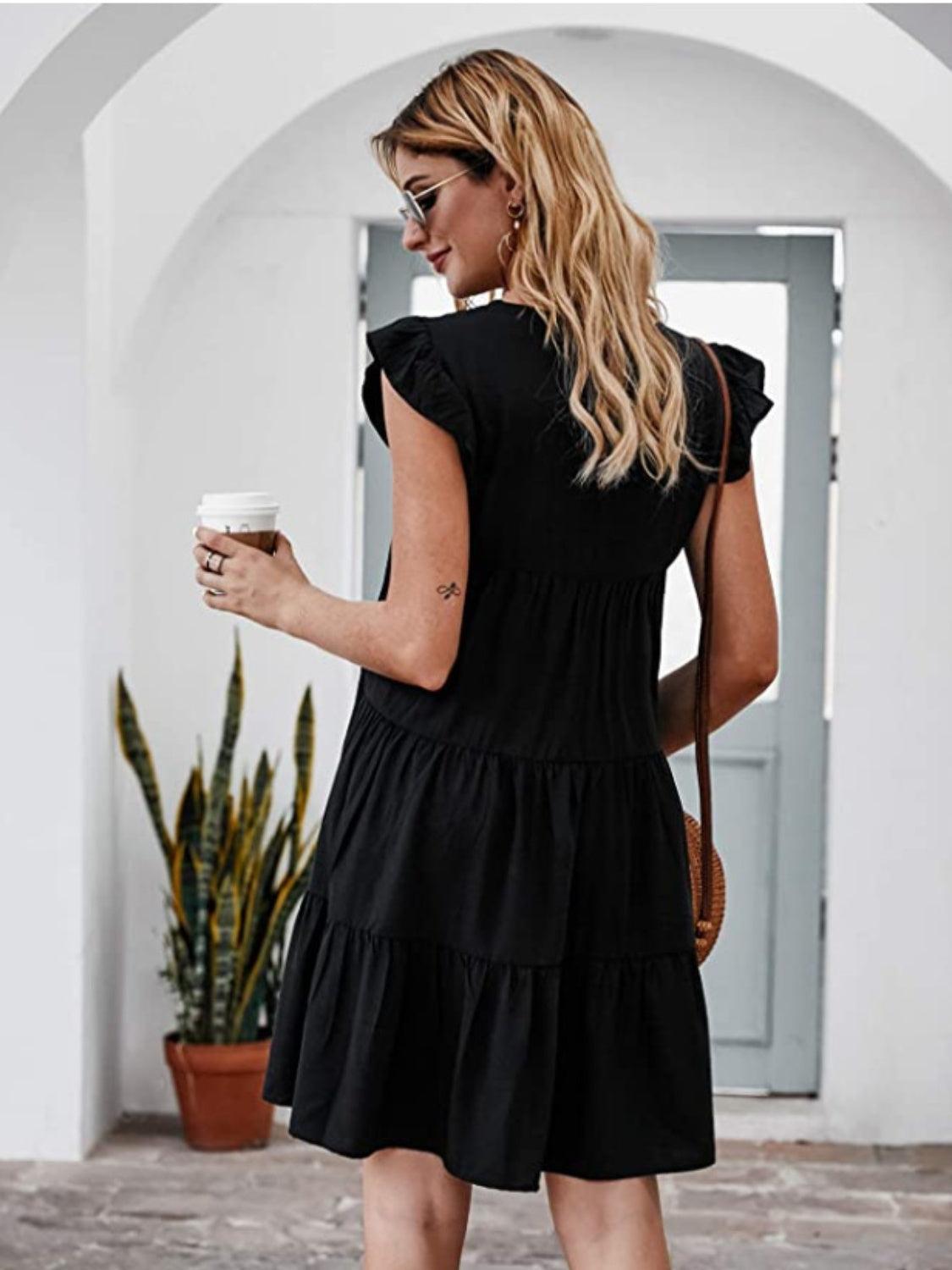 a woman in a black dress holding a cup of coffee